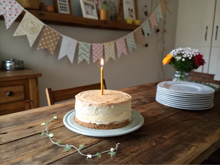 A minimalist birthday cake with a candle on a rustic table.